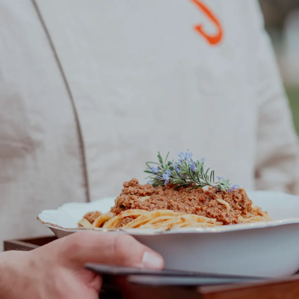 Chef che serve un piatto di pasta durante una cena privata in Toscana